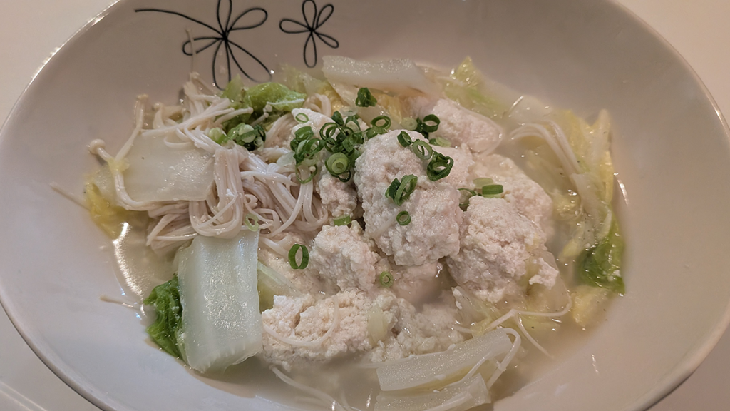 仕上げの生姜ときざみネギを添えて完成した鶏団子と白菜の生姜スープ鍋